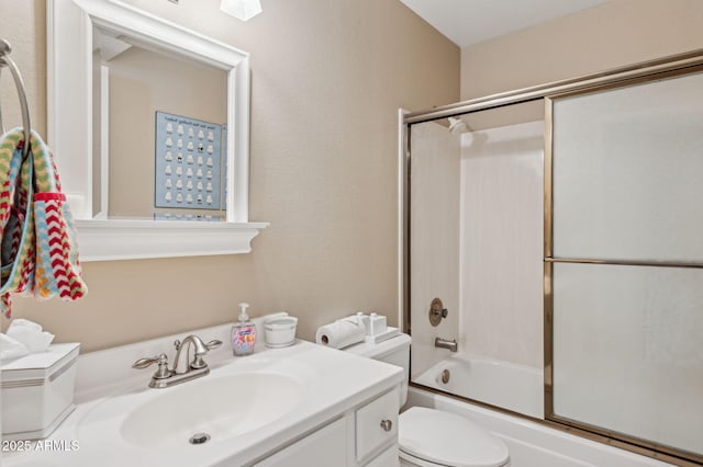 bathroom featuring bath / shower combo with glass door, vanity, and toilet