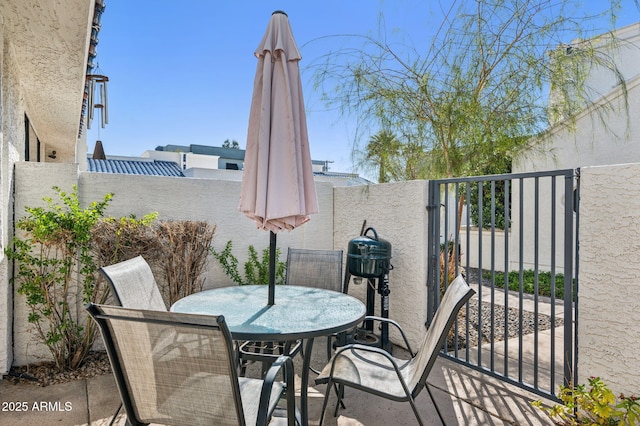 view of patio with outdoor dining space, a gate, and fence