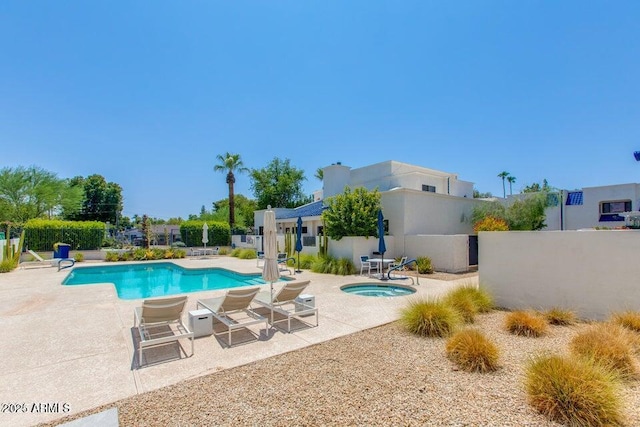 pool featuring a patio, fence, and a hot tub