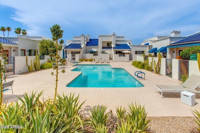 view of swimming pool with a patio area, a residential view, a fenced in pool, and fence