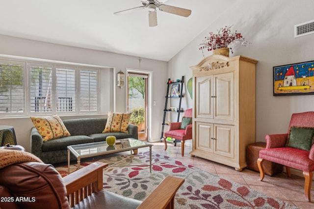 living area featuring light tile patterned floors, visible vents, a ceiling fan, and vaulted ceiling