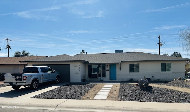 single story home featuring brick siding, driveway, an attached garage, and a shingled roof