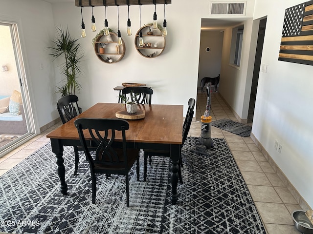 dining space with light tile patterned floors, baseboards, and visible vents