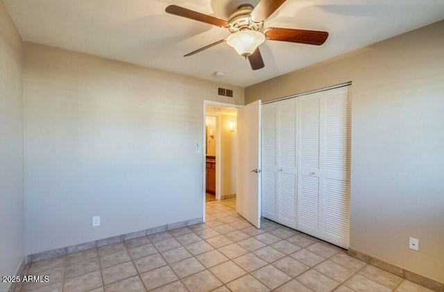 unfurnished bedroom with light tile patterned floors, a ceiling fan, baseboards, visible vents, and a closet