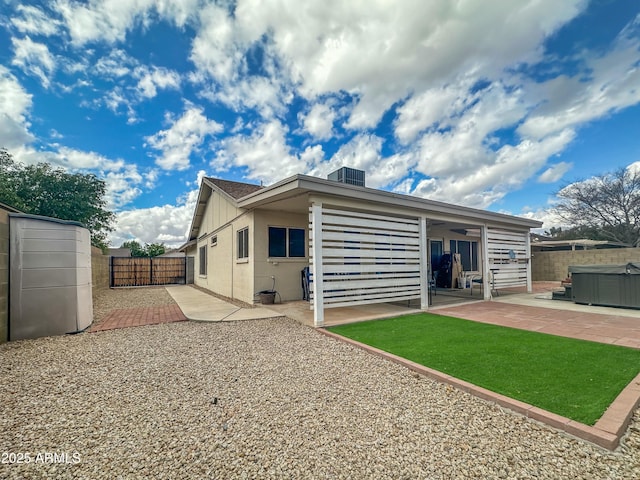 back of property featuring a hot tub and a patio area