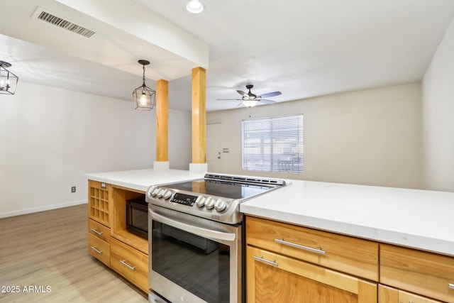 kitchen featuring black microwave, light wood-style flooring, visible vents, light countertops, and stainless steel electric range oven