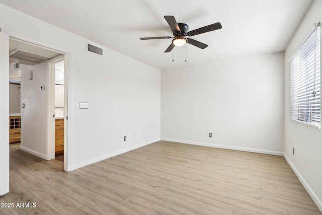 spare room featuring baseboards, light wood finished floors, visible vents, and a ceiling fan