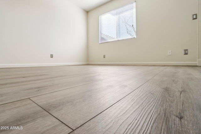 spare room with baseboards