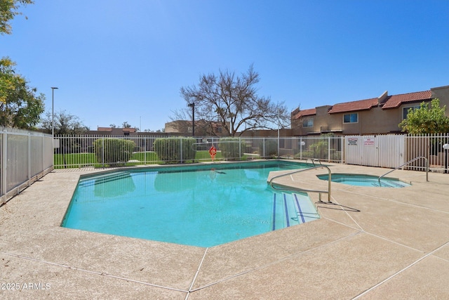 pool with a patio area, a hot tub, and fence