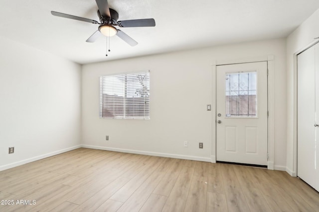 entrance foyer featuring light wood-style flooring, baseboards, and a wealth of natural light