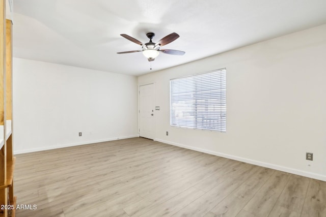 spare room featuring baseboards, a ceiling fan, and wood finished floors