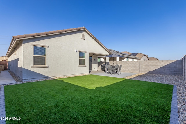 rear view of house with a yard and a patio