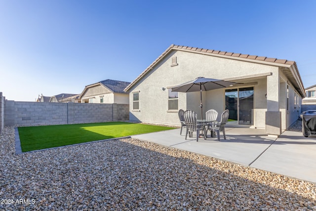 back of property featuring a lawn and a patio area