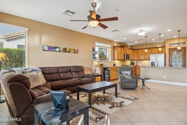 living room featuring light tile patterned floors, ceiling fan, and wine cooler