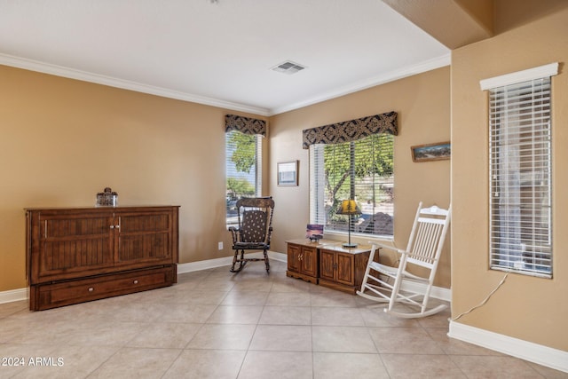 sitting room with ornamental molding and light tile patterned floors