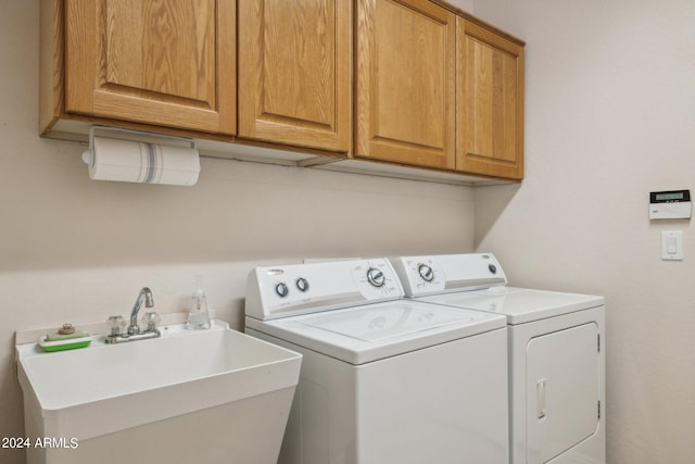 washroom with cabinets, sink, and washing machine and dryer