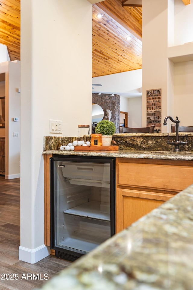 kitchen featuring stone counters, wine cooler, wood ceiling, and wood finished floors