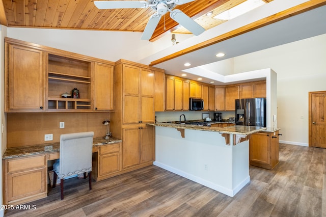 kitchen featuring a breakfast bar, vaulted ceiling, fridge with ice dispenser, dark stone counters, and a peninsula