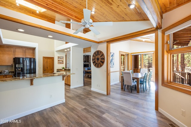 kitchen with wooden ceiling, recessed lighting, wood finished floors, baseboards, and black refrigerator with ice dispenser