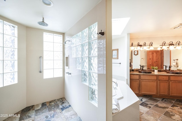 full bath with a tile shower, double vanity, a sink, and a bath