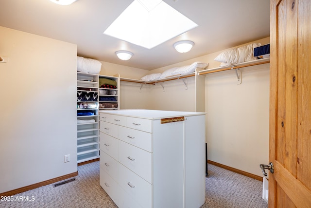 spacious closet with light carpet, a skylight, and visible vents