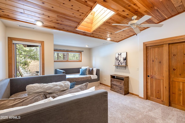 living room with light carpet, vaulted ceiling with skylight, baseboards, visible vents, and wood ceiling