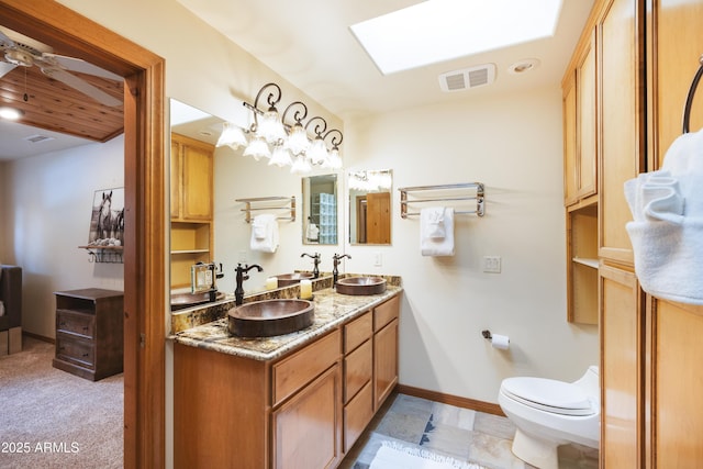 bathroom with a skylight, a sink, visible vents, and a ceiling fan