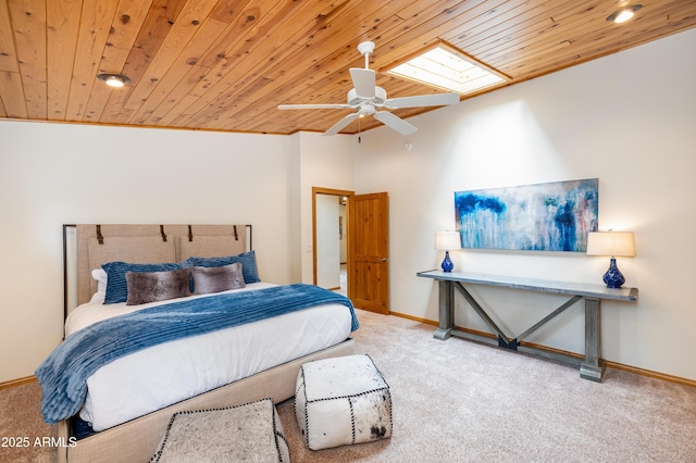 carpeted bedroom featuring wooden ceiling, baseboards, lofted ceiling with skylight, and a ceiling fan