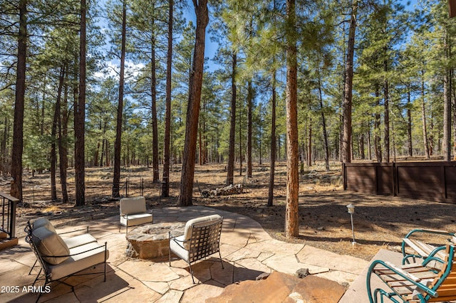 view of patio with an outdoor fire pit and fence