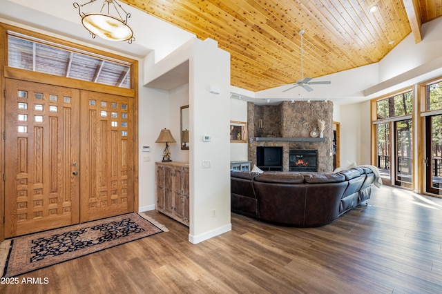 foyer entrance with baseboards, wooden ceiling, wood finished floors, a fireplace, and high vaulted ceiling