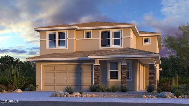 view of front of home with an attached garage, stone siding, concrete driveway, and stucco siding