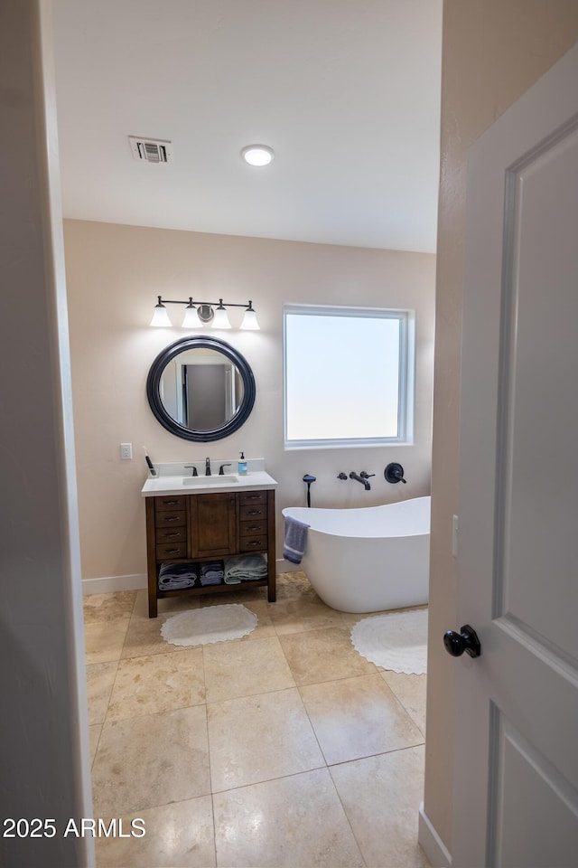 bathroom with tile patterned floors, vanity, and a washtub