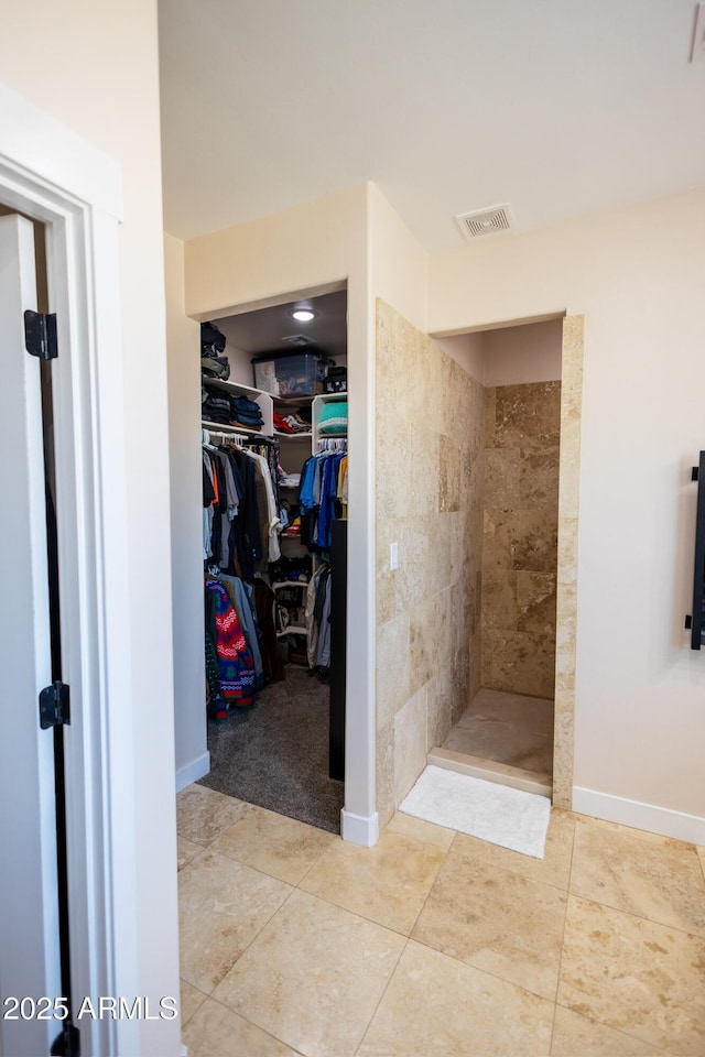 bathroom featuring a tile shower and tile patterned floors