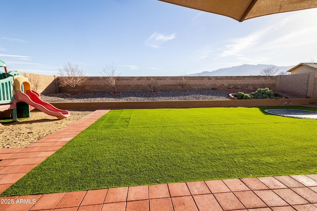 view of yard with a mountain view and a playground