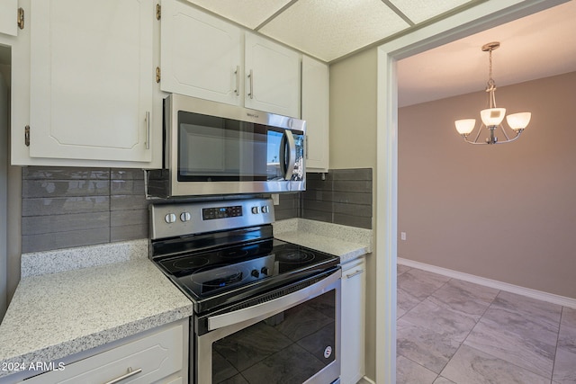 kitchen with white cabinetry, stainless steel appliances, an inviting chandelier, decorative light fixtures, and decorative backsplash