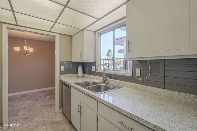 kitchen with white cabinetry, sink, an inviting chandelier, stainless steel dishwasher, and decorative backsplash