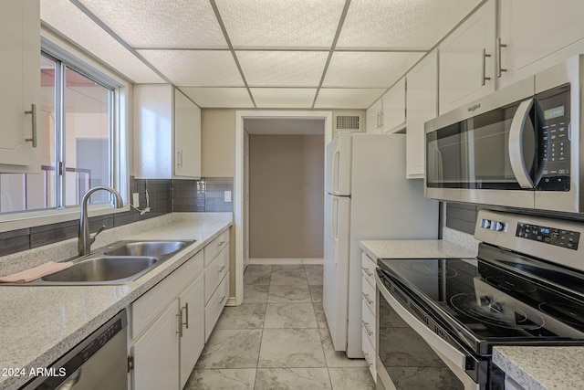 kitchen with appliances with stainless steel finishes, white cabinetry, and sink