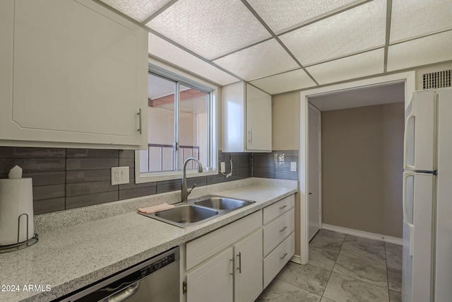 kitchen featuring sink, dishwasher, white refrigerator, decorative backsplash, and white cabinets