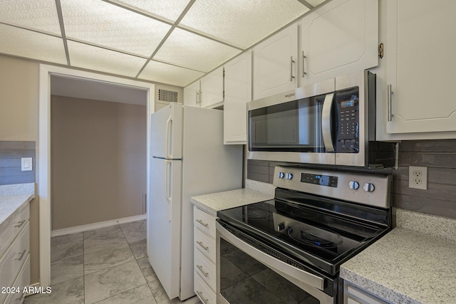 kitchen featuring a paneled ceiling, white cabinetry, and appliances with stainless steel finishes