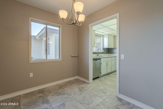 unfurnished dining area with a chandelier and sink