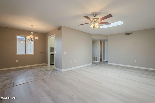 spare room with ceiling fan with notable chandelier and light wood-type flooring