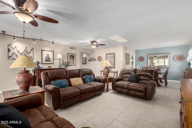 living room with ceiling fan, light tile patterned flooring, a textured ceiling, and track lighting