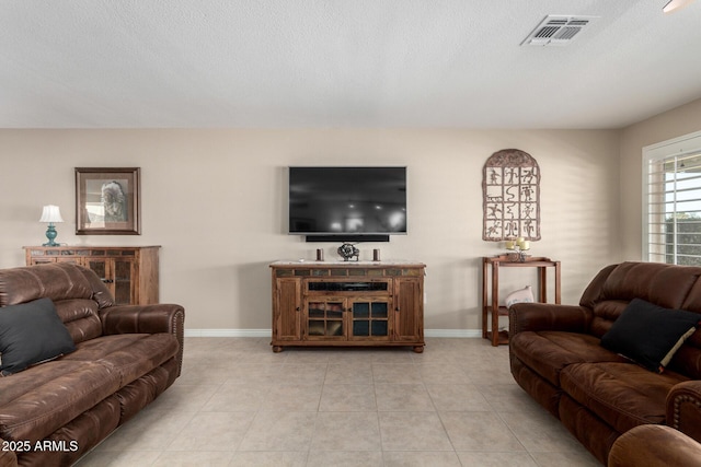 living room featuring a textured ceiling and light tile patterned flooring