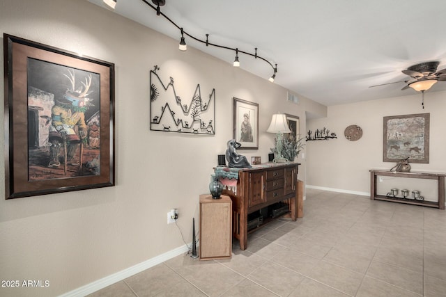 hallway featuring rail lighting and light tile patterned flooring