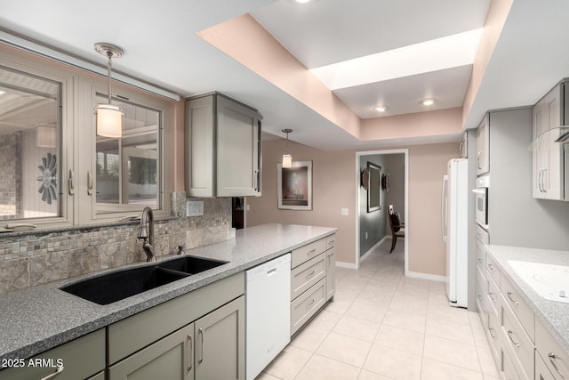 kitchen with white appliances, sink, backsplash, hanging light fixtures, and gray cabinetry