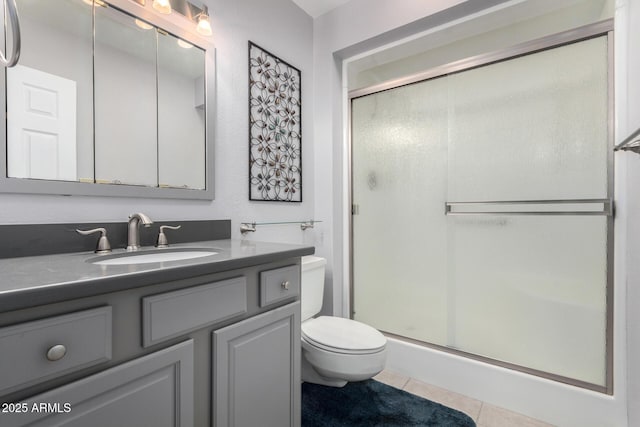 bathroom featuring toilet, an enclosed shower, tile patterned floors, and vanity