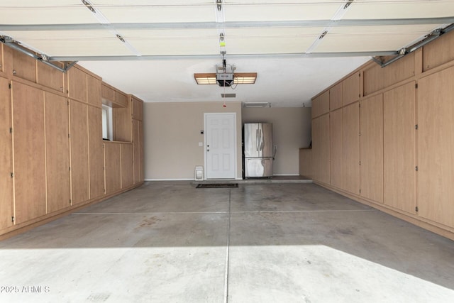 garage with stainless steel refrigerator and a garage door opener