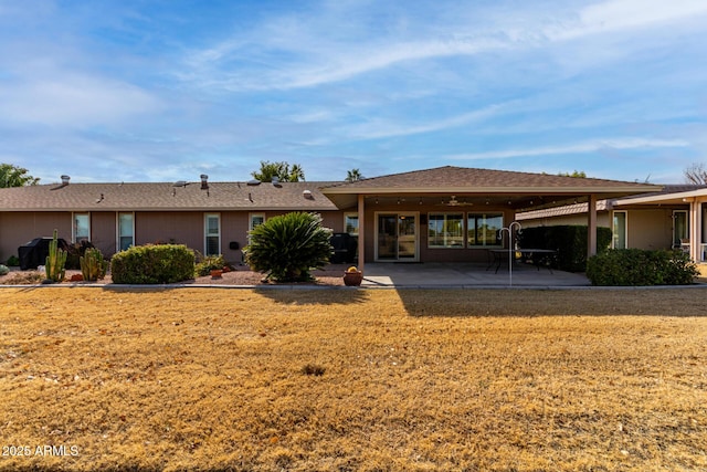 back of property featuring a patio area and a yard