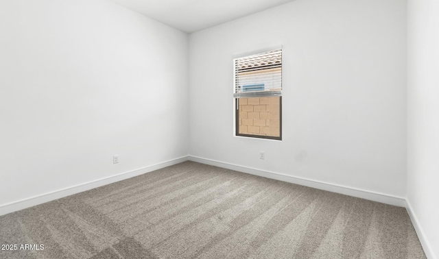 empty room featuring carpet floors and baseboards
