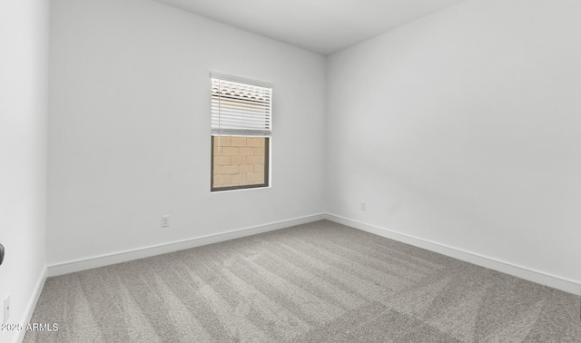 carpeted empty room with baseboards